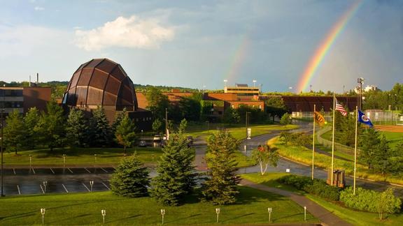 Aerial view of campus that includes a double rainbow near the planetarium
