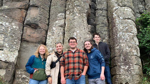 A group of 5 UMD students in front of a rock wall during their study abroad trip to Dublin