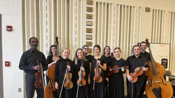The UMD Chamber Orchestra posing with their stringed instruments