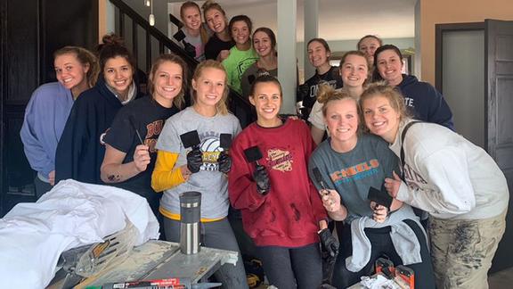 UMD volleyball team painting a home for Habitat for Humanity 