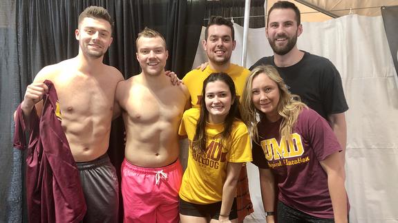 Members of the student club UMDUnified standing in swimwear smiling at camera