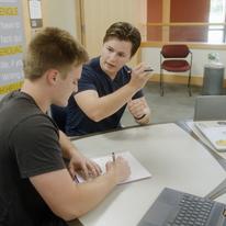 Josh Curry works with another student in the Tutoring Center