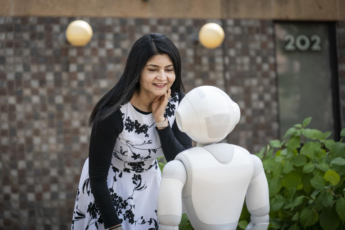 Professor Arshia Khan outside Kirby with one of her robots