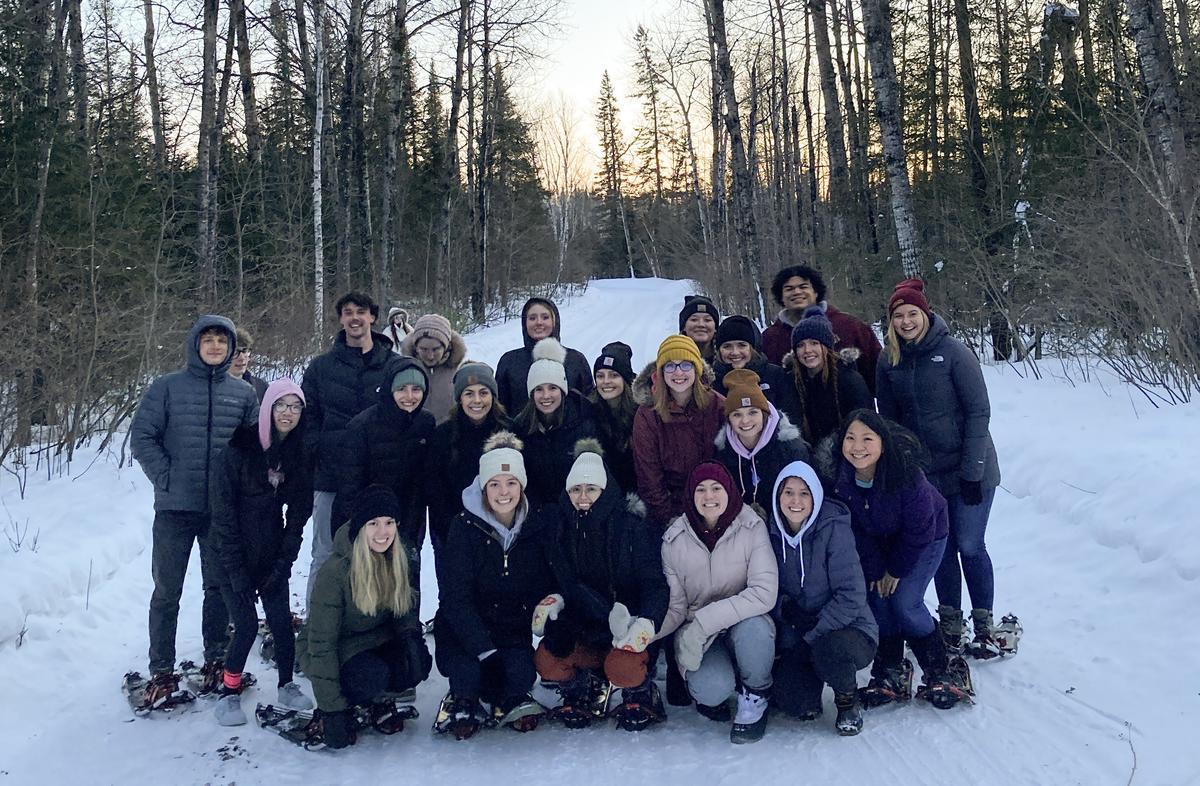 A group of college students in the woods in winter.