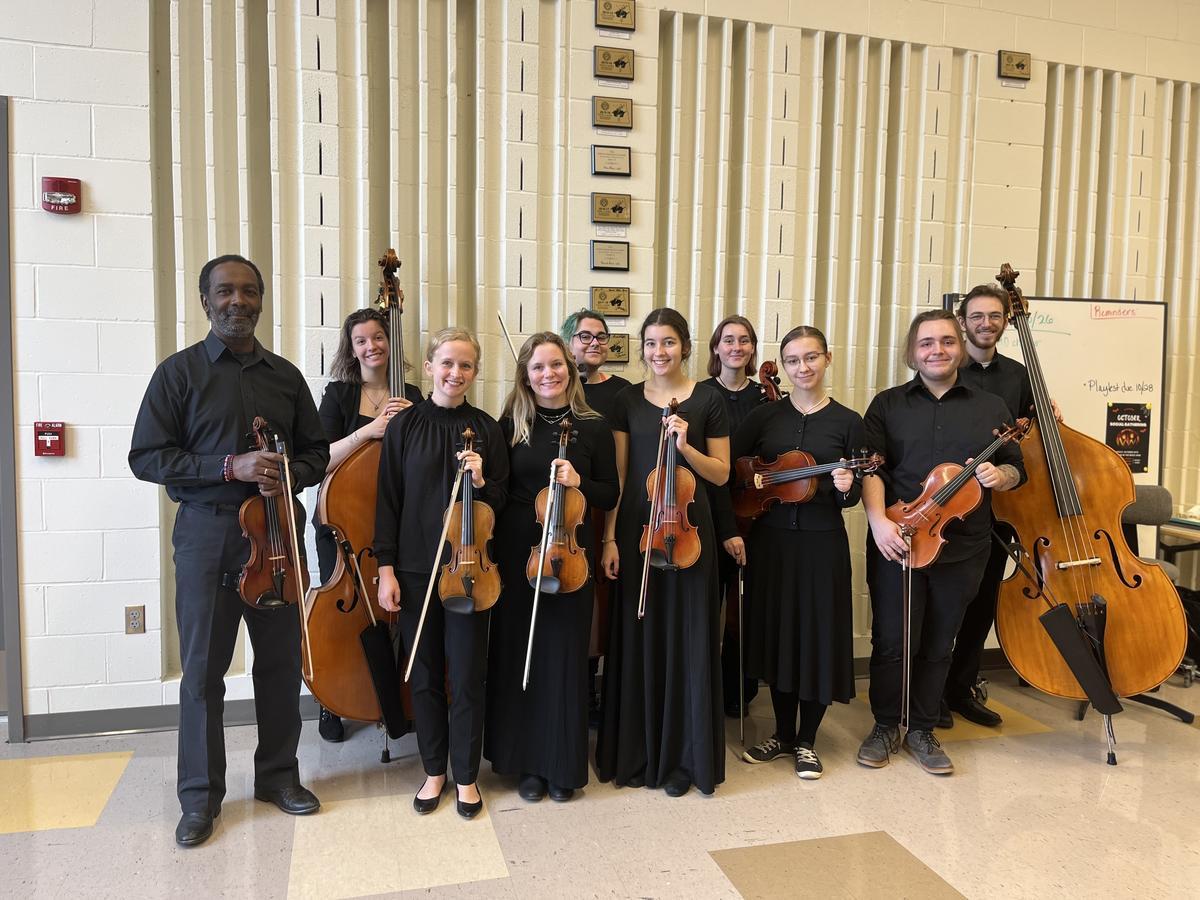 The UMD Chamber Orchestra posing with their stringed instruments