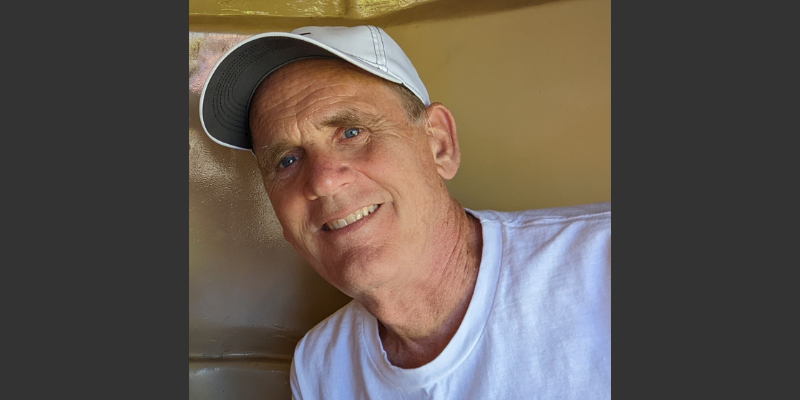 Kent Brorson, smiling and wearing a white shirt and ball cap
