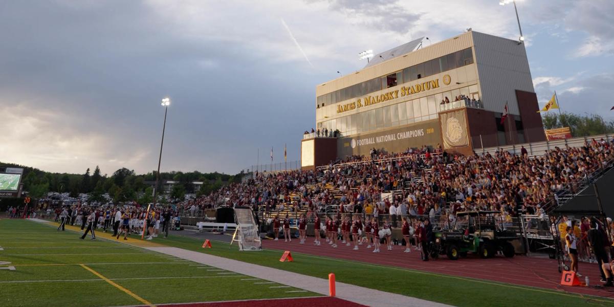 The stands filled with fans while evening light plays across Malosky Stadium.