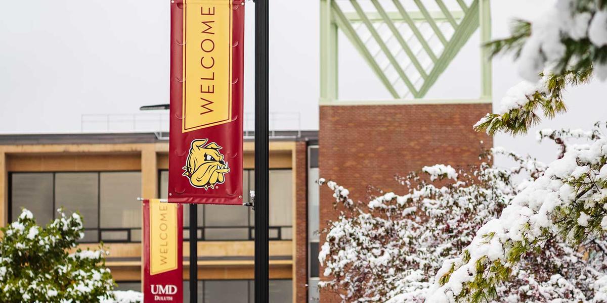 UMD Boulevard banners welcoming people on a snowy campus, with Kirby Student Center in the background.