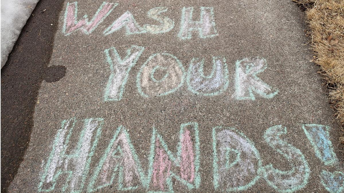 Photo of chalk drawing that says "Wash Your Hands"