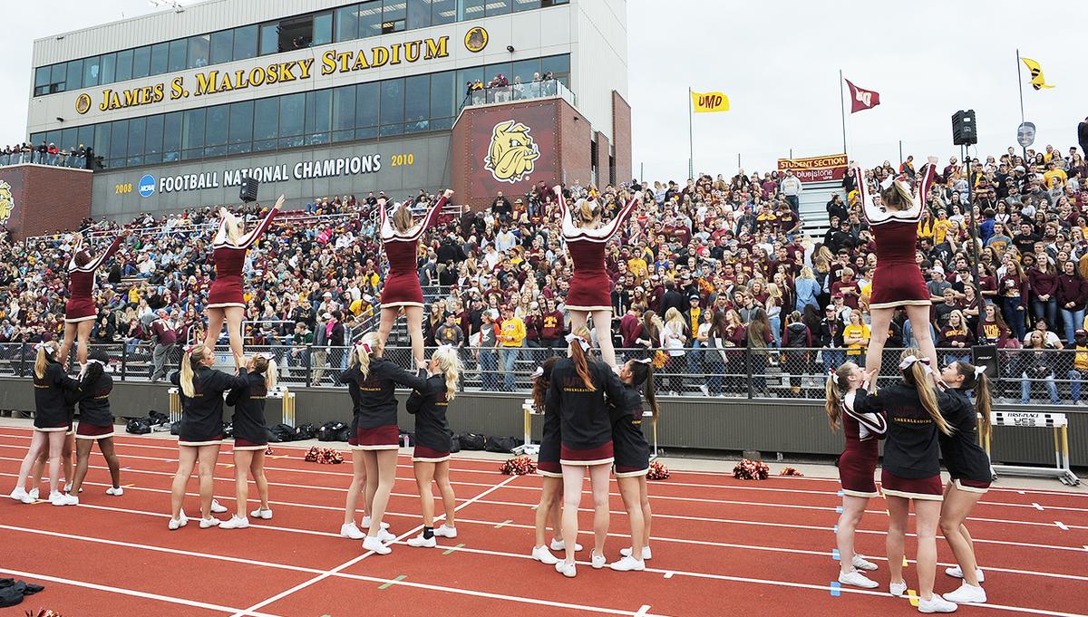 Cheerleaders and the crowd at a UMD Homecoming football game