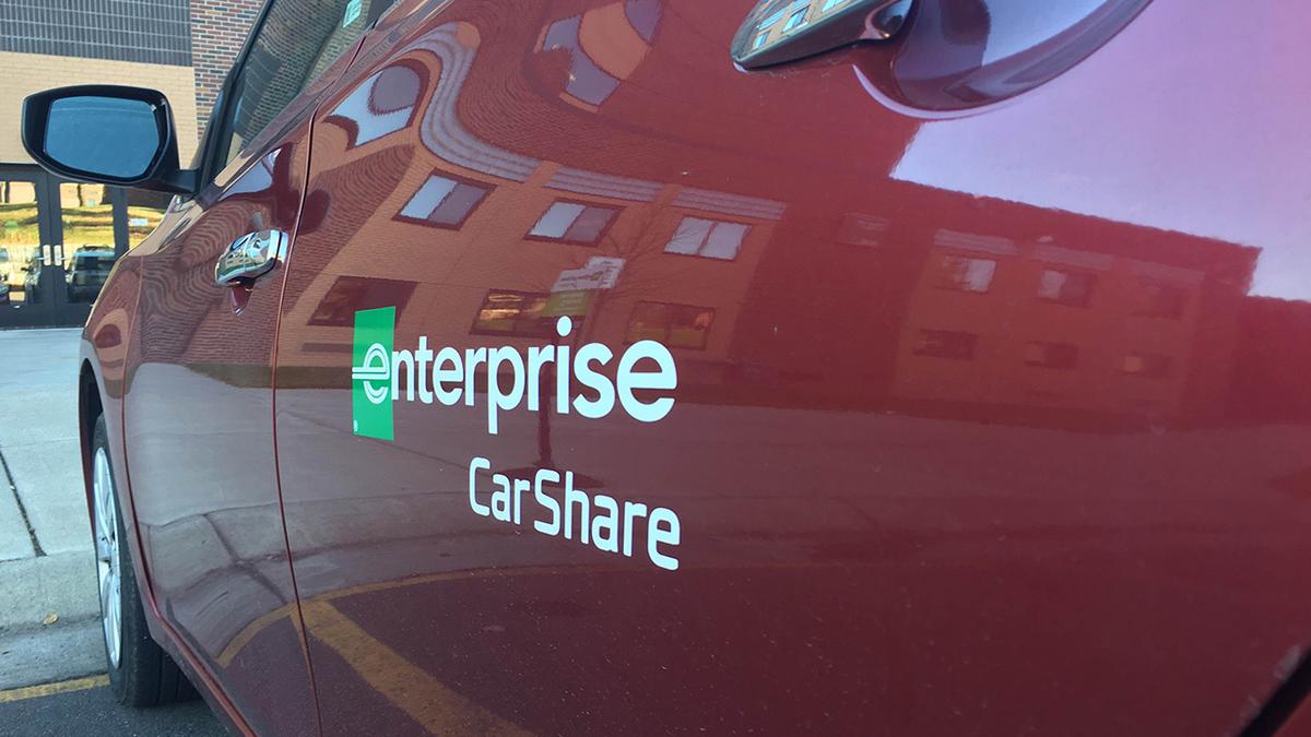 Enterprise car share sign next to the red car share vehicle