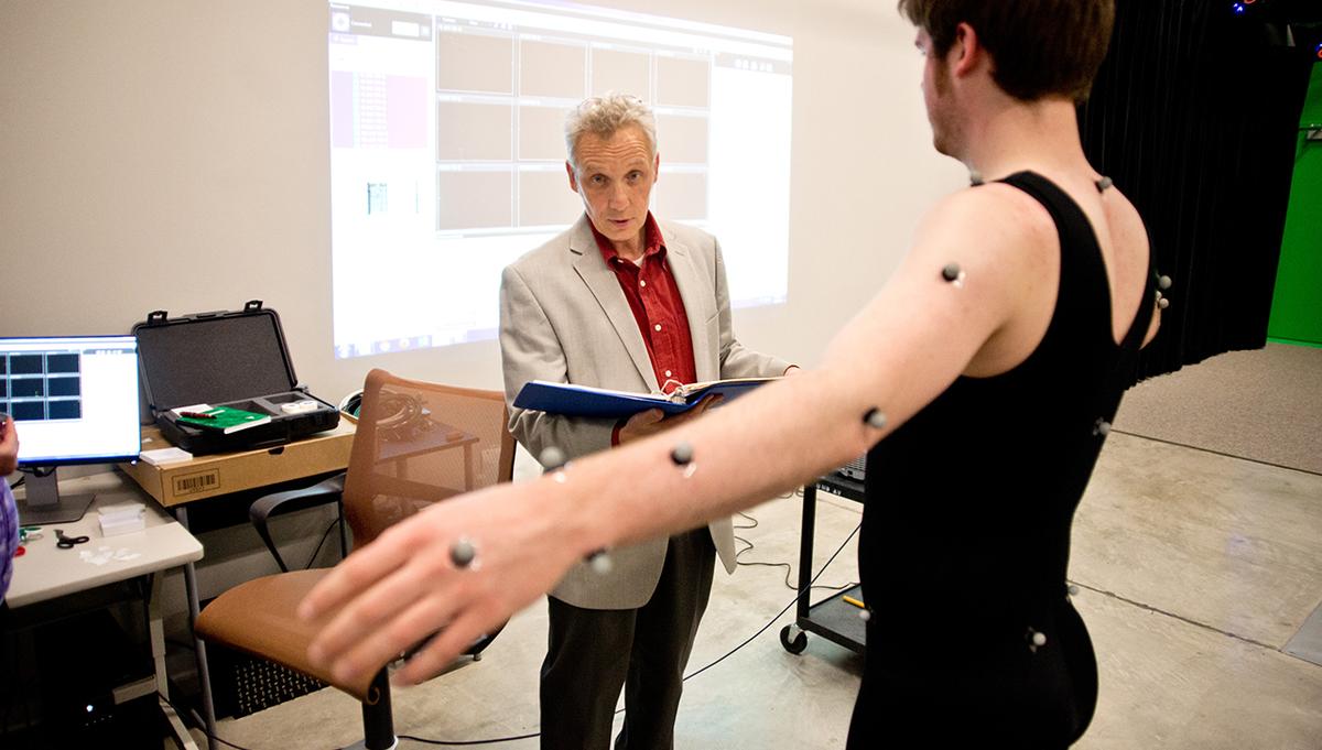 A professor looking at a dancers movement through MMAD Lab motion capture