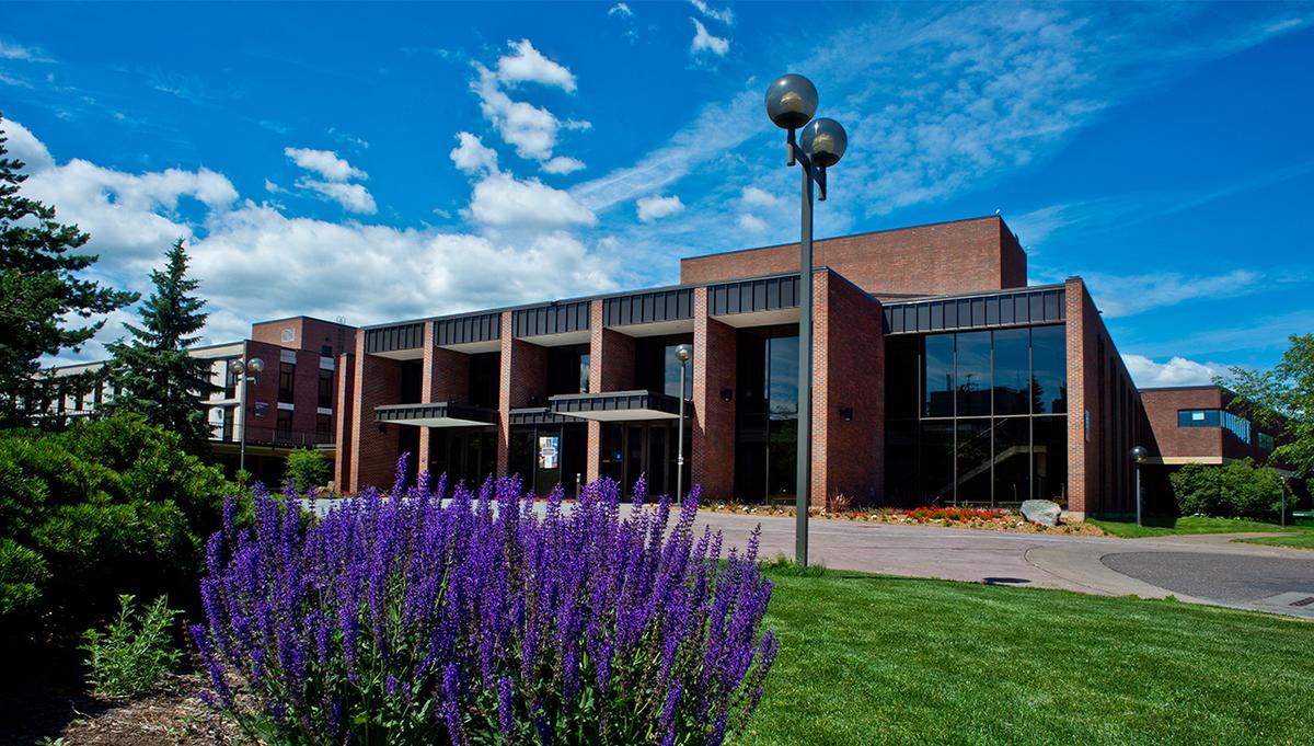 The exterior of the Marshall Performing Arts Center with purple flowers in the corner.