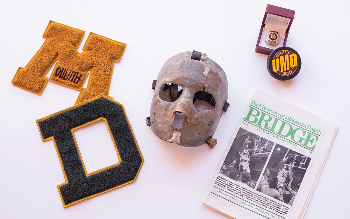 An image showing artifacts from UMD's history. Two patches, goalie mask, championship ring, hockey puck, and a Bridge magazine. 