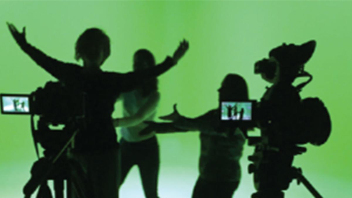 Silhouettes of people in front of green screen