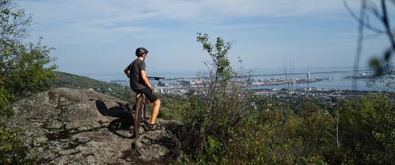 Brandon Stachewicz pauses mountain biking to take in the view of Lake Superior and the city of Duluth