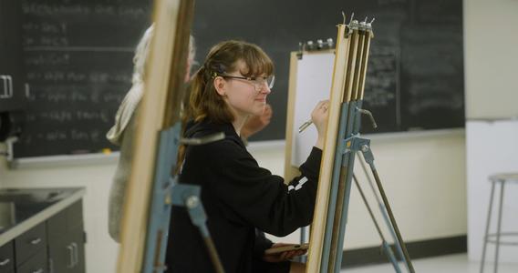 A student draws at an art easel in the drawing studio in AB Anderson Hall at UMD.