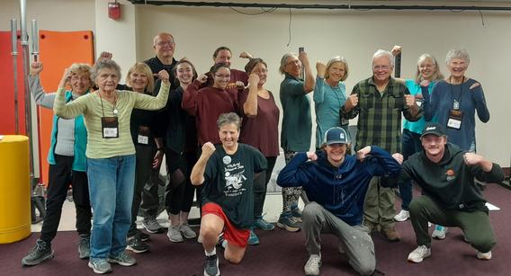 Chuck Fountaine, assistants, and Resistance Training for Seniors participants flexing