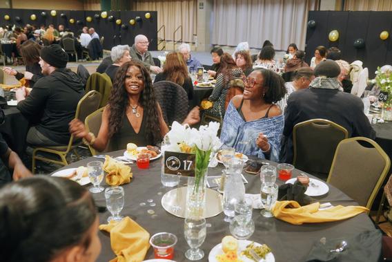 Elizabeth Manly-Spain and fellow students are seated around a dinner table at the annual Soul Food Dinner at the University of Minnesota Duluth.