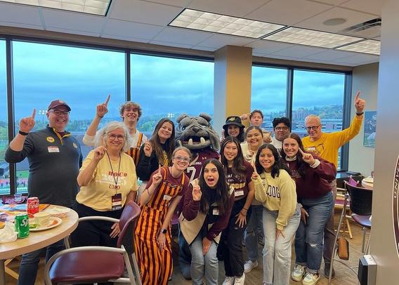 A group of students and faculty pose for a photo with mascot Champ, a bulldog.