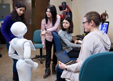 Modern photo of Computer Science professor, her students, and their robot