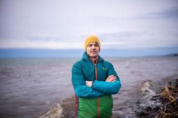 Assistant Professor Craig Hill standing on the Lake Superior shore.