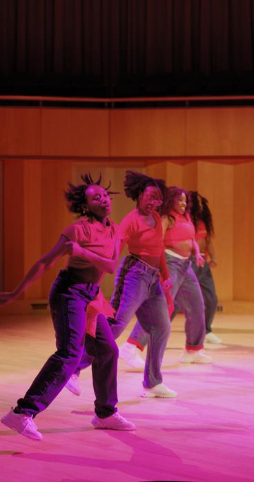 The BSA Dance Team, wearing matching red shirts and blue jeans, performs on stage at Weber Music Hall during the annual Soul Food Dinner event.