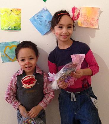 Children hold bags of art supplies