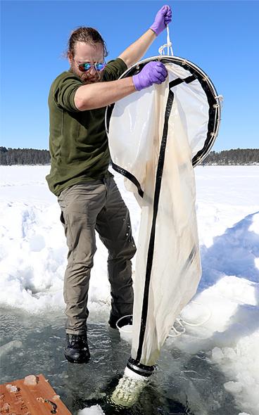 Ted Ozersky, a UMN Duluth assistant professor of biology, samples winter populations of zooplankton (tiny animals that eat algae and in turn are eaten by fish). 