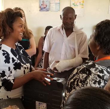BJ Allen (left) and Muzalema Mwanza (center) bring a solar suitcase to a health clinic.