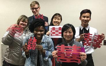 Playing with scissors is part of the language class. The group cut out the figure "double happiness" in honor of the Chinese Year of the Monkey.  Back row (left to right): Stephanie Zanmiller, Calvin Miner, Mai Che Lee, and Devon Diaz. In front are Sharon
