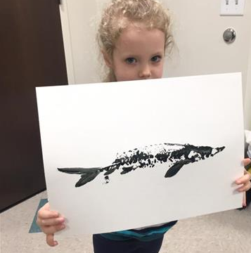 A girl holds up a print she made of a young sturgeon through a process known as Gyotaku. She participated in an event held last February for the Sturgeon Spectacular in Fond du Lac, Wisconsin.  Credit: Ryuta Nakajima