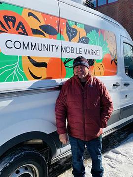 UMD graduate student Karl Becker standing in front of the Community Mobile Market van
