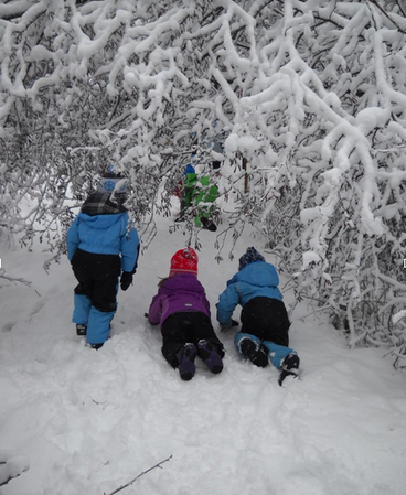Three children crawl in the snow.