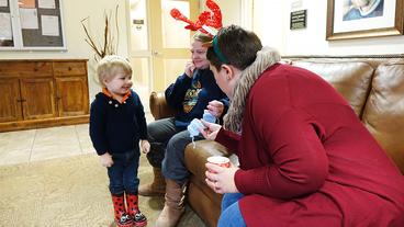 Young child looks at scarf with two adults at the Steve O'Neil Apartments in Duluth