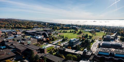 An aerial view of campus with a cloud inversion over Lake Superior