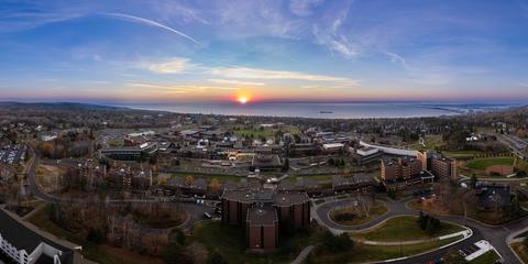 The sun just starting to rise over Lake Superior and the UMD campus in an aerial drone shot