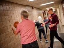 An exercise science student guides three community seniors through an exercise with basketballs