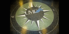 A terrazzo floor with an inlay of a compass with UMD and the shape of Lake Superior