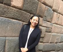 UMD Professor Jennifer Gómez Menjívar standing in front of stone wall