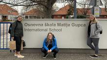 UMD Education students Cass Welhouse, Alexia Bjerke, and Megan Blaszkowski, in front of Croatian international school sign. 